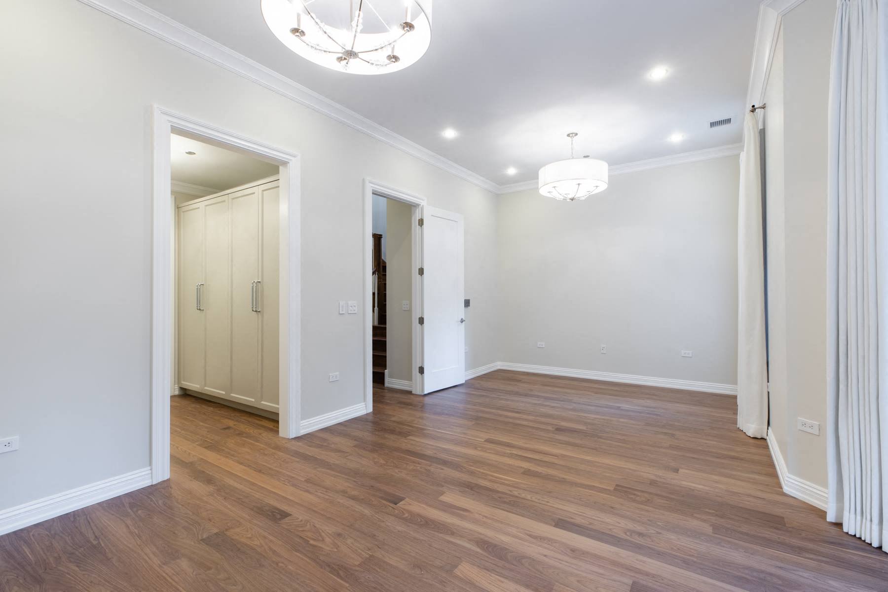 a renovated living room with white walls and wood floors