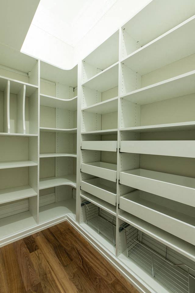 a large walk in closet with empty shelves