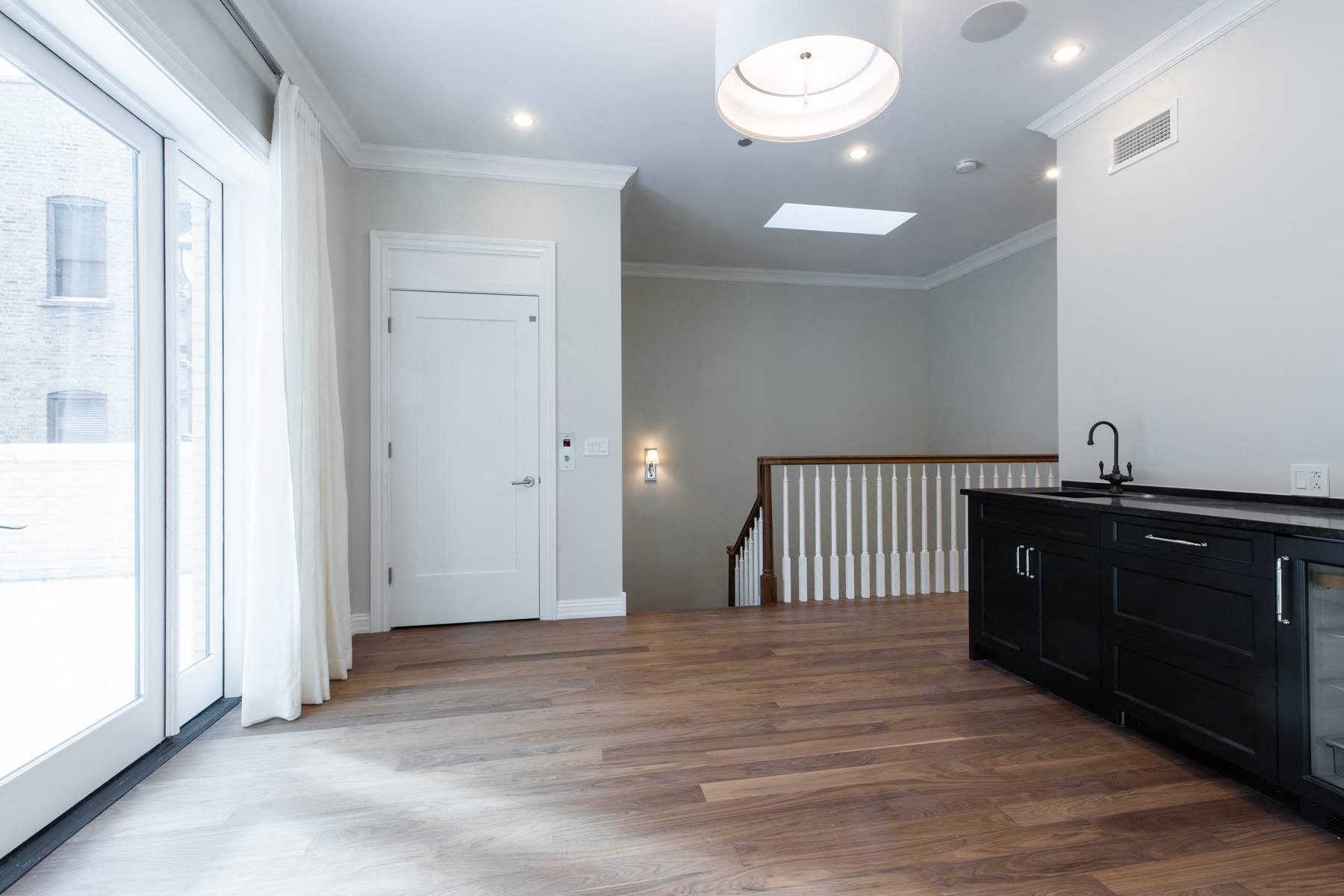 a renovated kitchen and living room with a door to a staircase