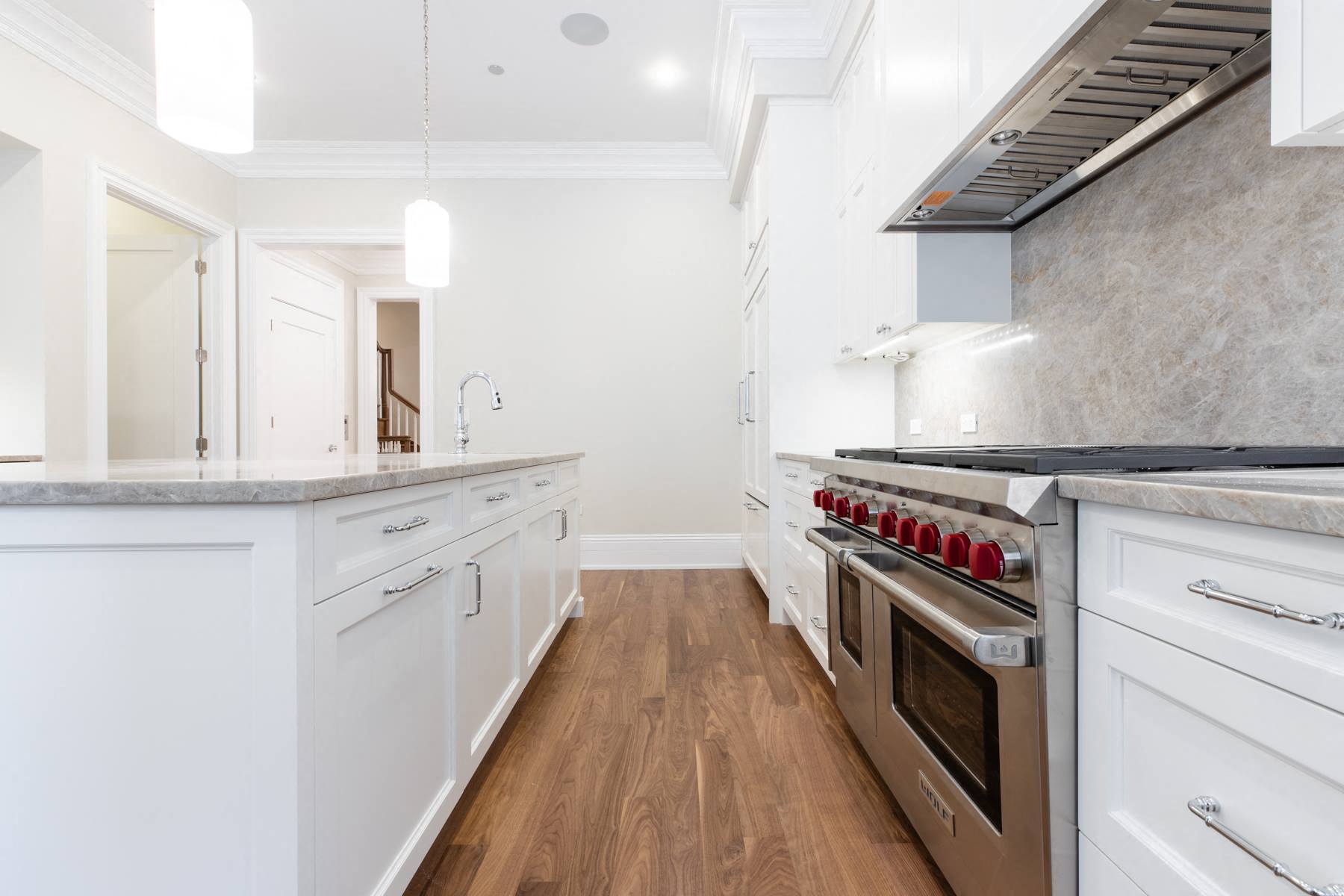 a large white kitchen with stainless steel appliances and white cabinets