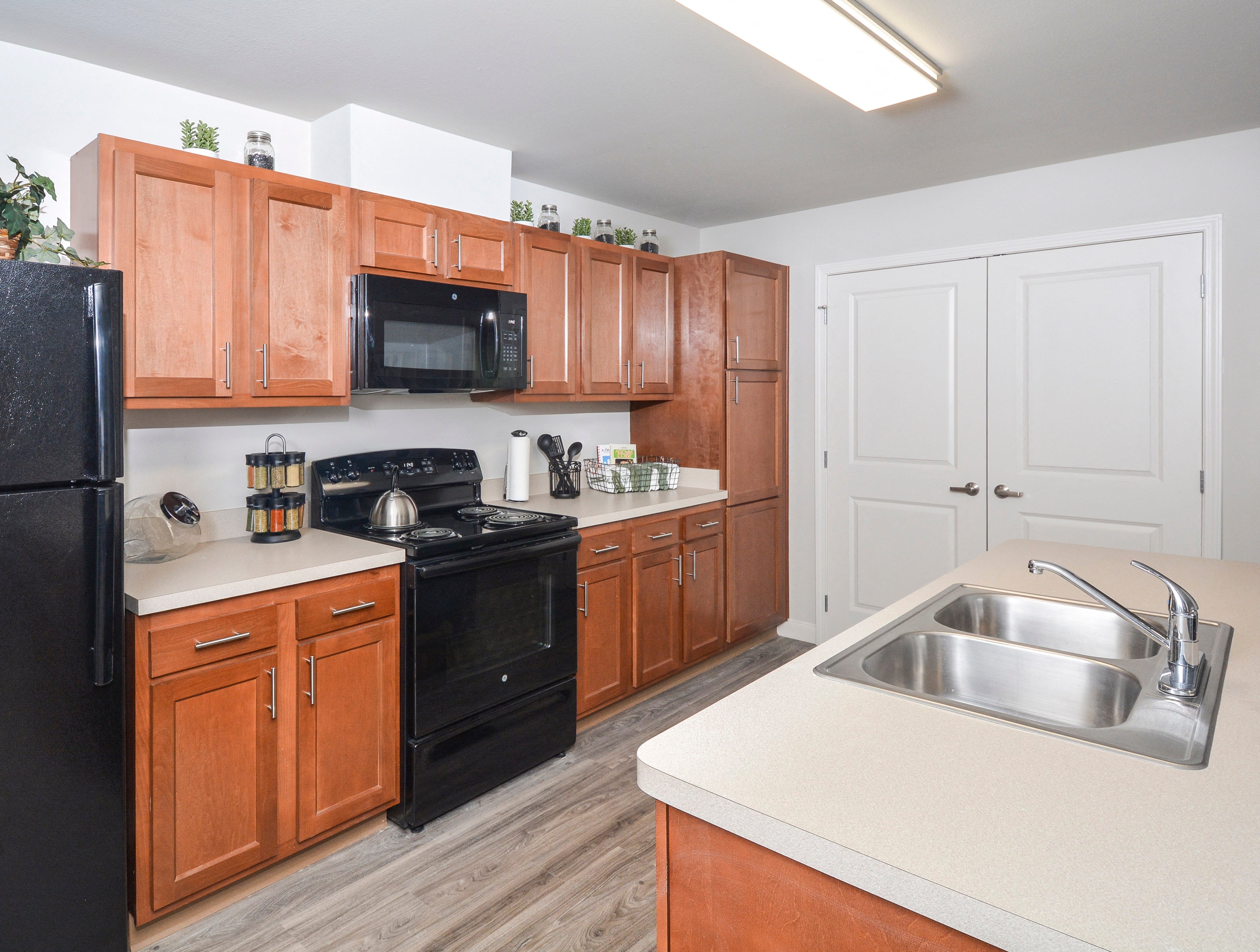 A kitchen with wooden cabinets and black appliances.