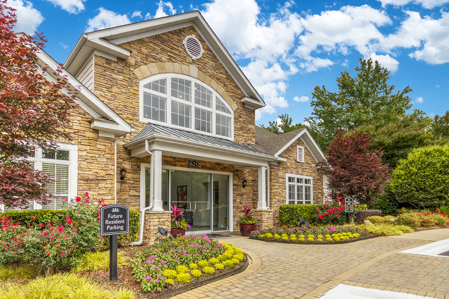 the front of a brick house with a sign in front of it