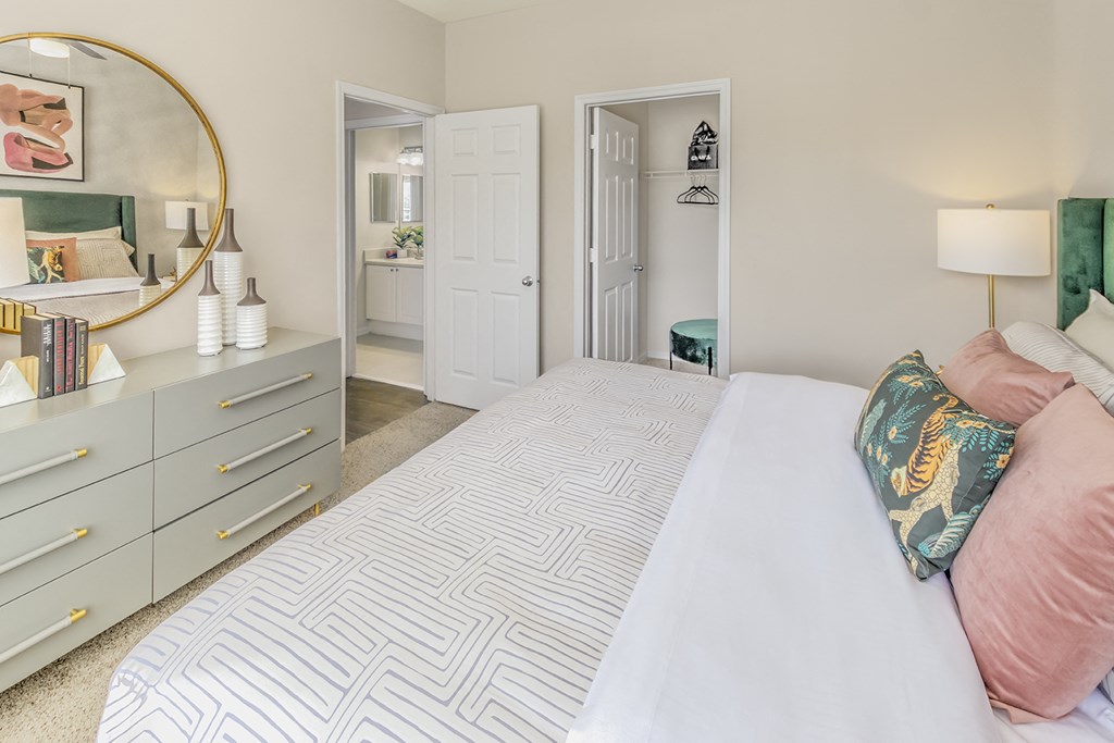 a bedroom with a large white bed and a mirror