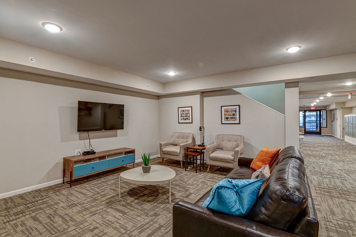 a living room with a leather couch and a television