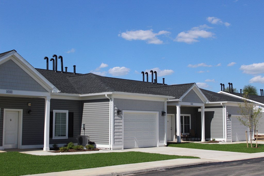 a white house with a gray roof and a lawn