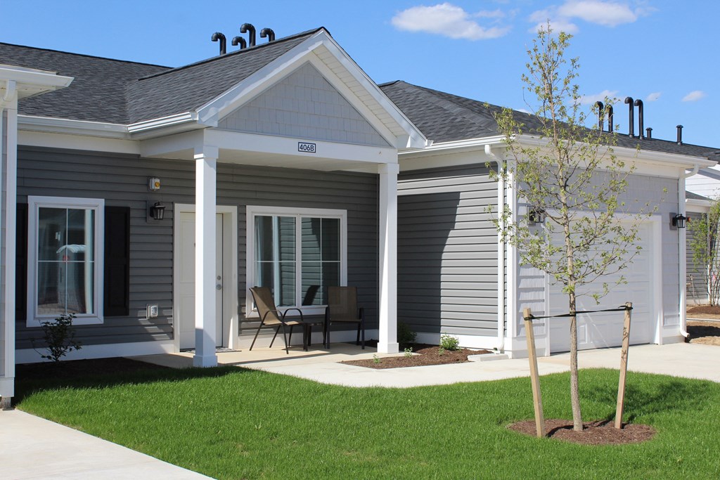 a home with a patio and a tree in the yard
