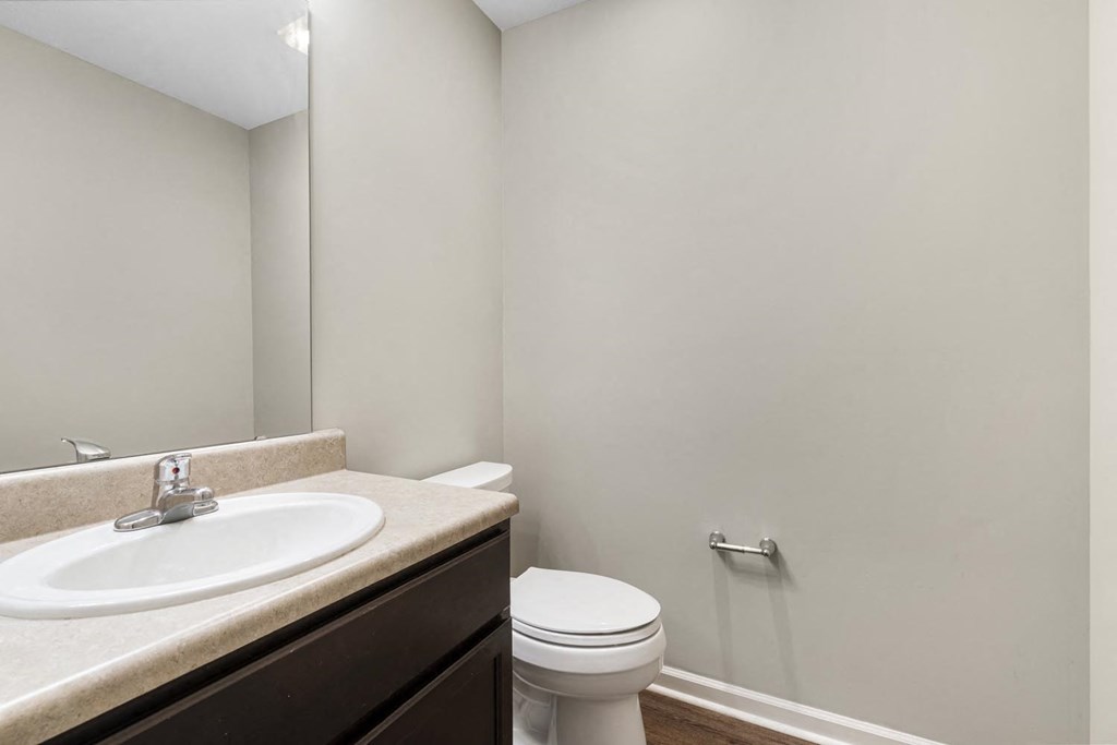 a bathroom with a sink toilet and a mirror
