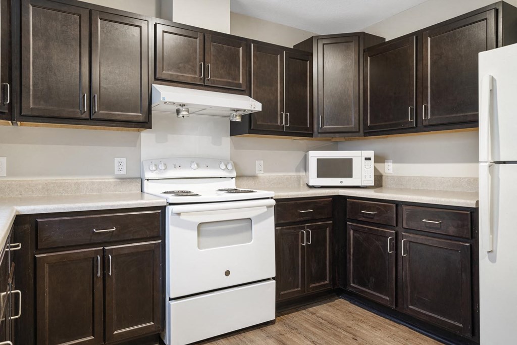 a kitchen with white appliances and dark wood cabinets