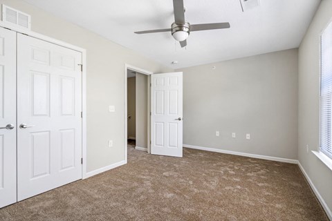 a bedroom with two doors and a ceiling fan