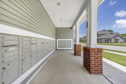 a long porch with mailboxes and a house in the background