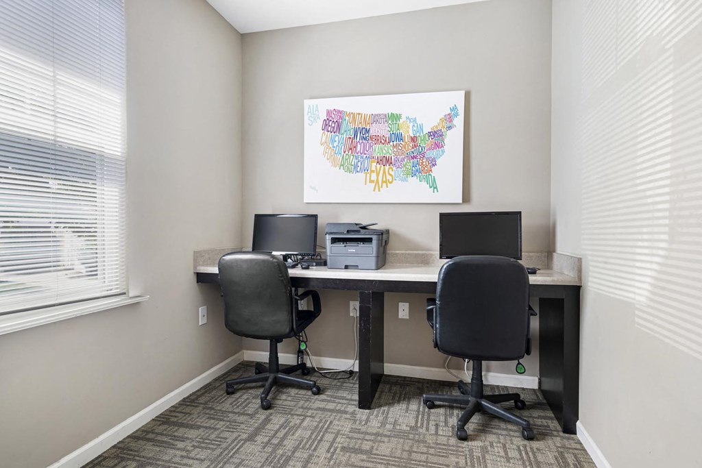 an office with two desks and two chairs and a printer