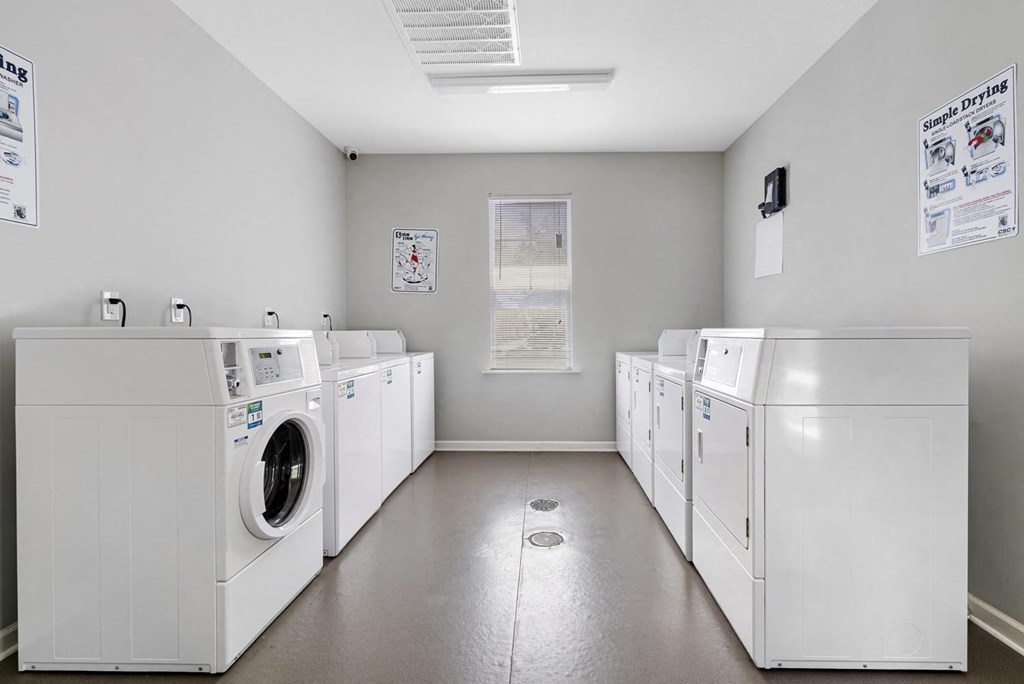 a group of washes and dryers in a laundry room