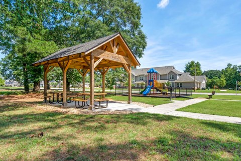 a picnic pavilion with a playground in a park