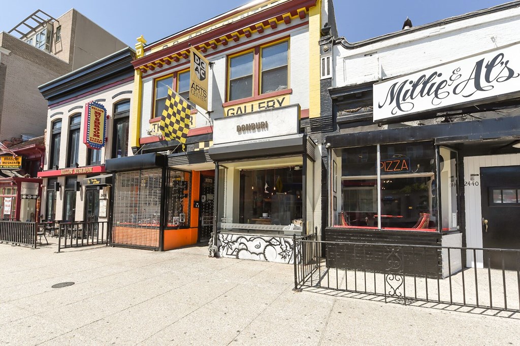 a street view of a row of shops on a sidewalk