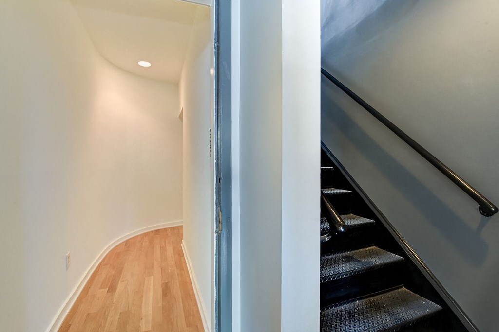 a staircase in a home with a blue wall and a wood floor