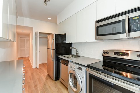 a kitchen with stainless steel appliances and white cabinets