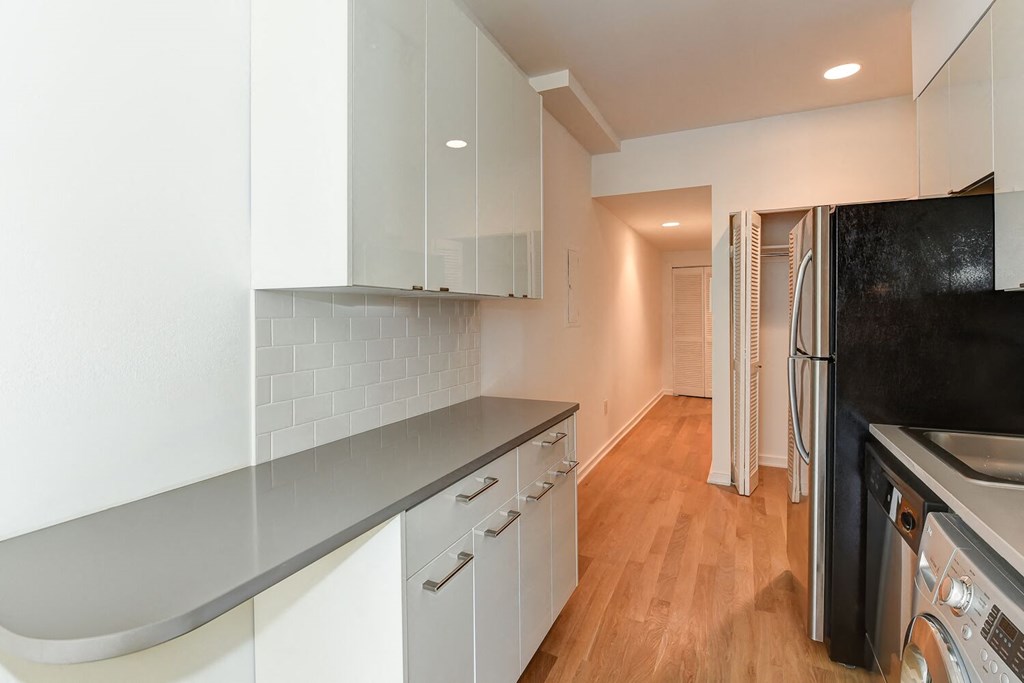 a kitchen with white cabinets and a black refrigerator
