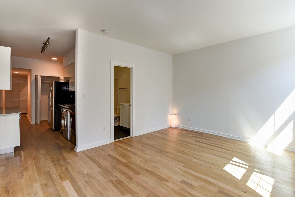a living room with a hard wood floor and white walls