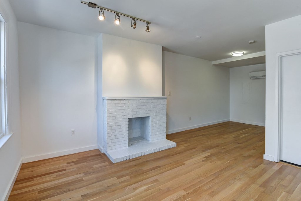 a living room with a fireplace and a wooden floor
