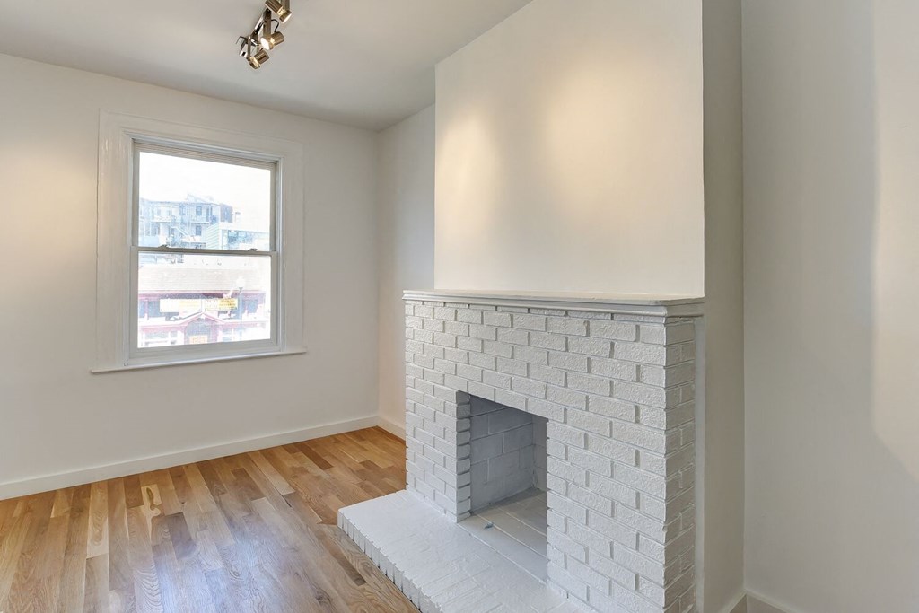 a living room with a brick fireplace and a window