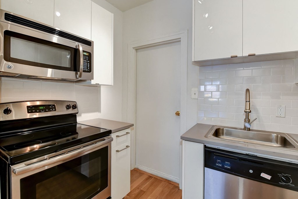 a kitchen with stainless steel appliances and white cabinets
