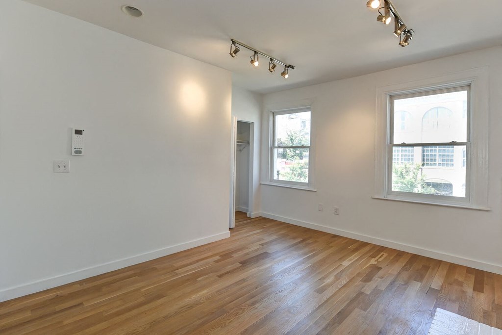 a living room with a hard wood floor and two windows