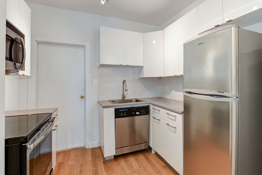 a kitchen with stainless steel appliances and white cabinets
