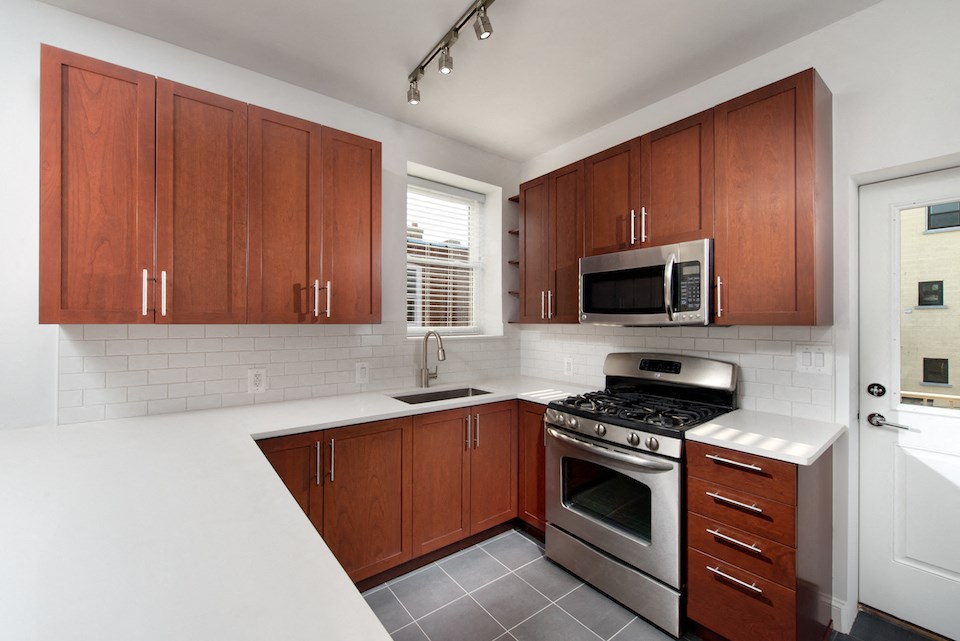 a kitchen with wooden cabinets and stainless steel appliances and a window