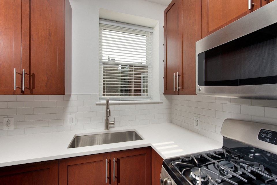 a kitchen with a sink and a microwave and a window