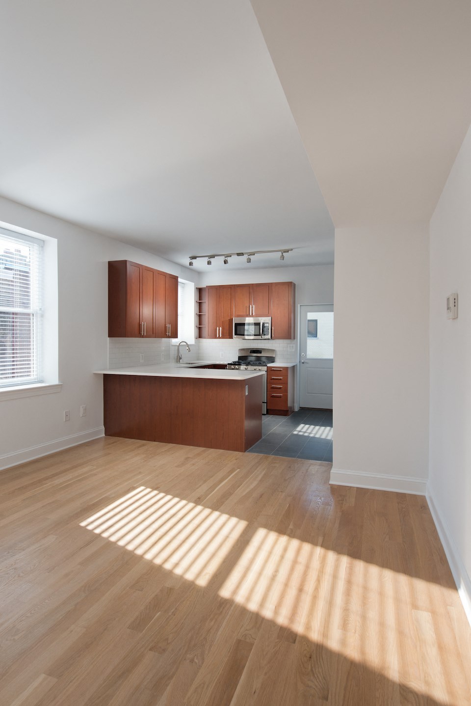 an empty kitchen with wood floors and wooden cabinets