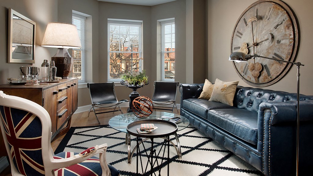 a living room with blue leather furniture and a large wall clock