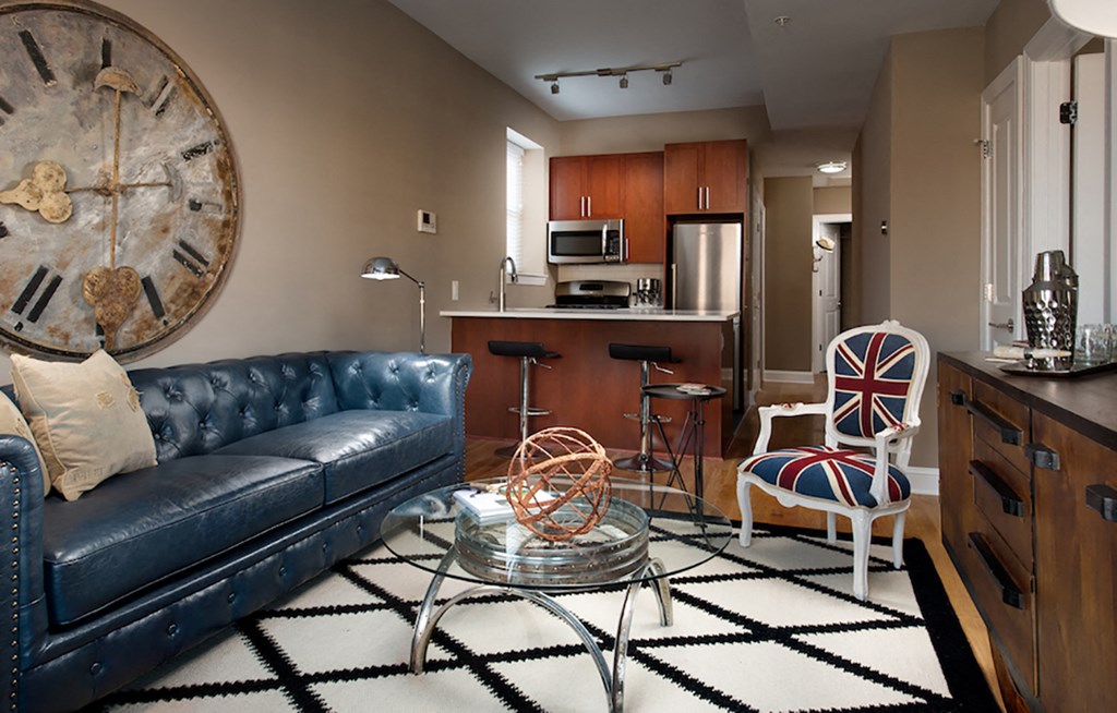 a living room with a leather couch and a table with two chairs