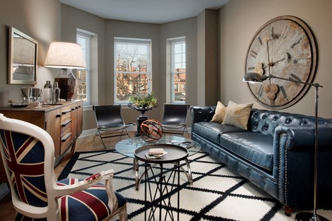 a living room with a blue leather couch and a rug