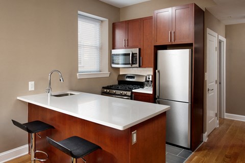 a kitchen with a white counter top and a refrigerator