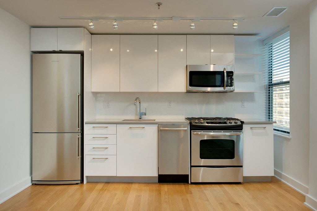 a kitchen with white cabinets and stainless steel appliances