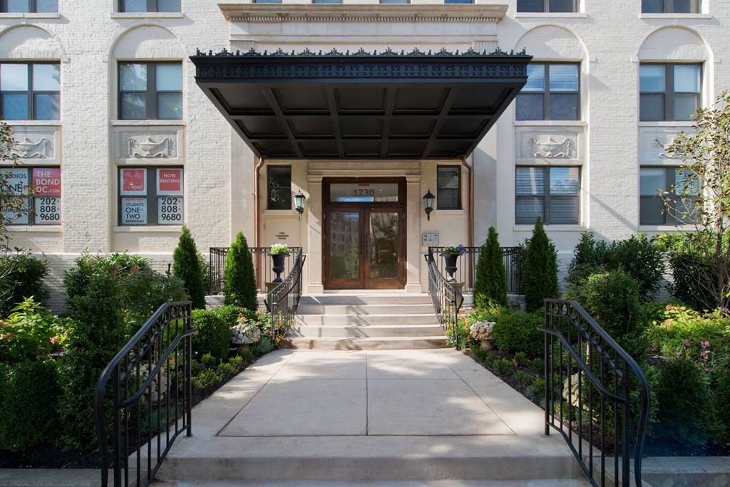 the front of an apartment building with stairs and a door
