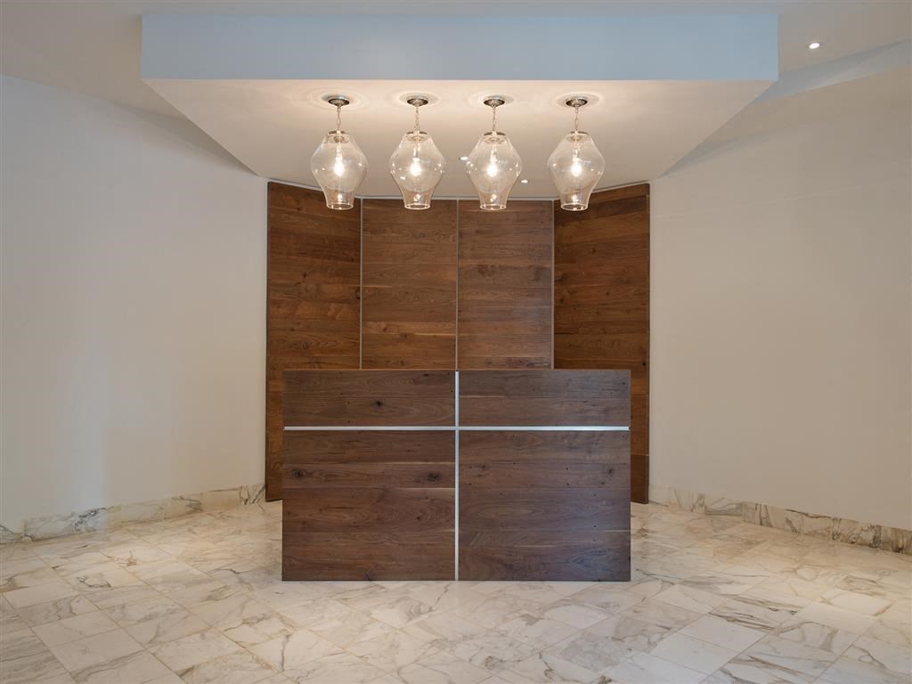 a wood wall with four lamps and a marble floor