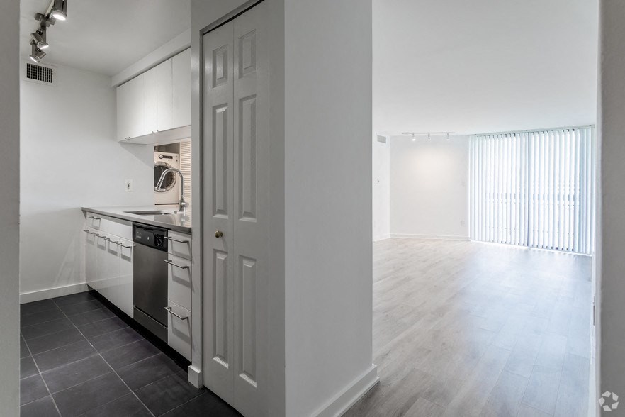an empty kitchen and living room with a white door