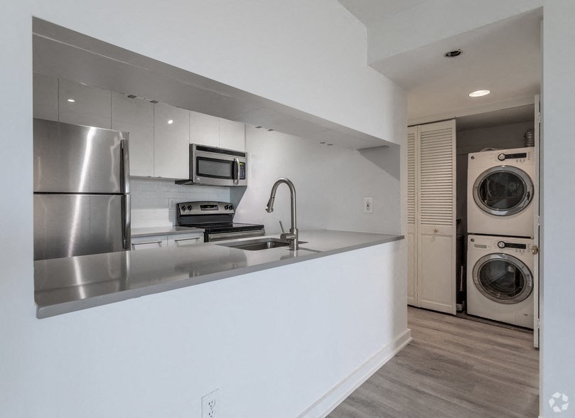 a kitchen with a washing machine and a washer and dryer in a house