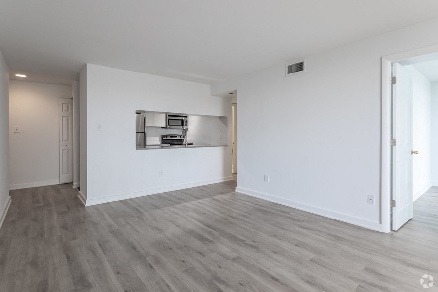 an empty living room with white walls and wood flooring