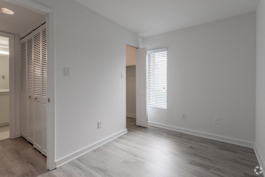 the living room of an empty house with white walls and wood floors
