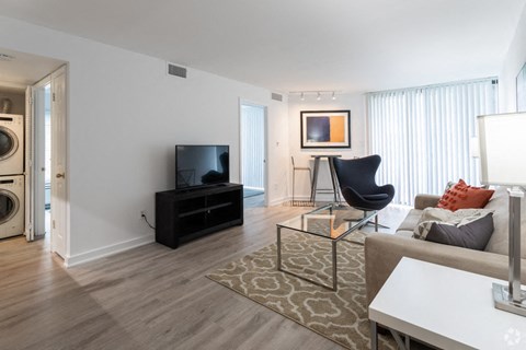 a living room with a couch and a television and a washing machine