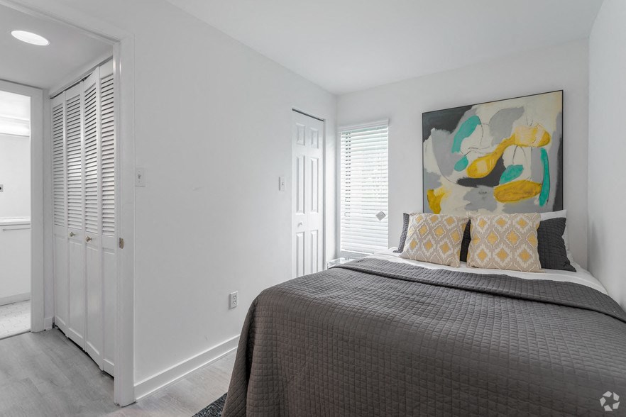 a bedroom with a bed and a painting on the wall