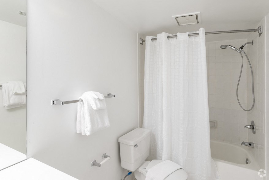 a bathroom with a shower and a toilet and a shower curtain