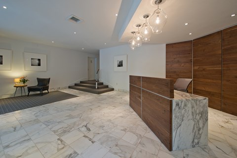 a marble lobby with a reception desk and a staircase