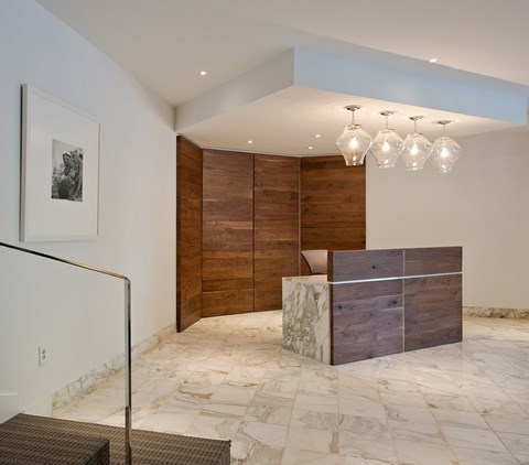 a reception area with a marble reception desk and a wood wall