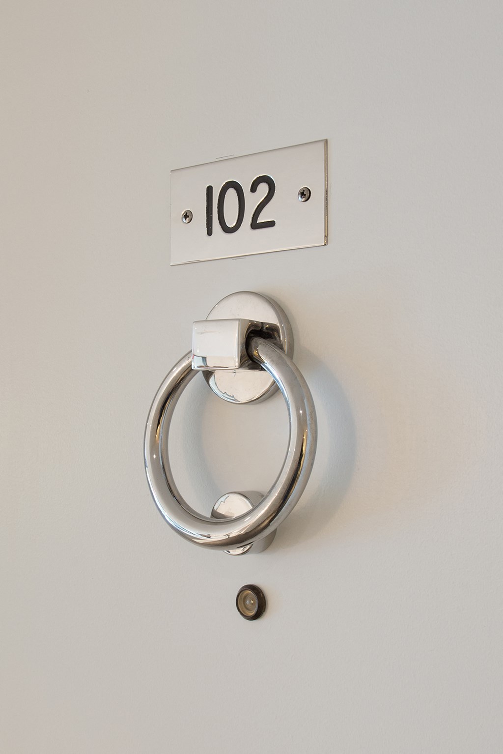 a silver door handle with a number on a white wall
