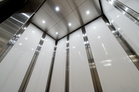 a row of elevators in a building with glass walls