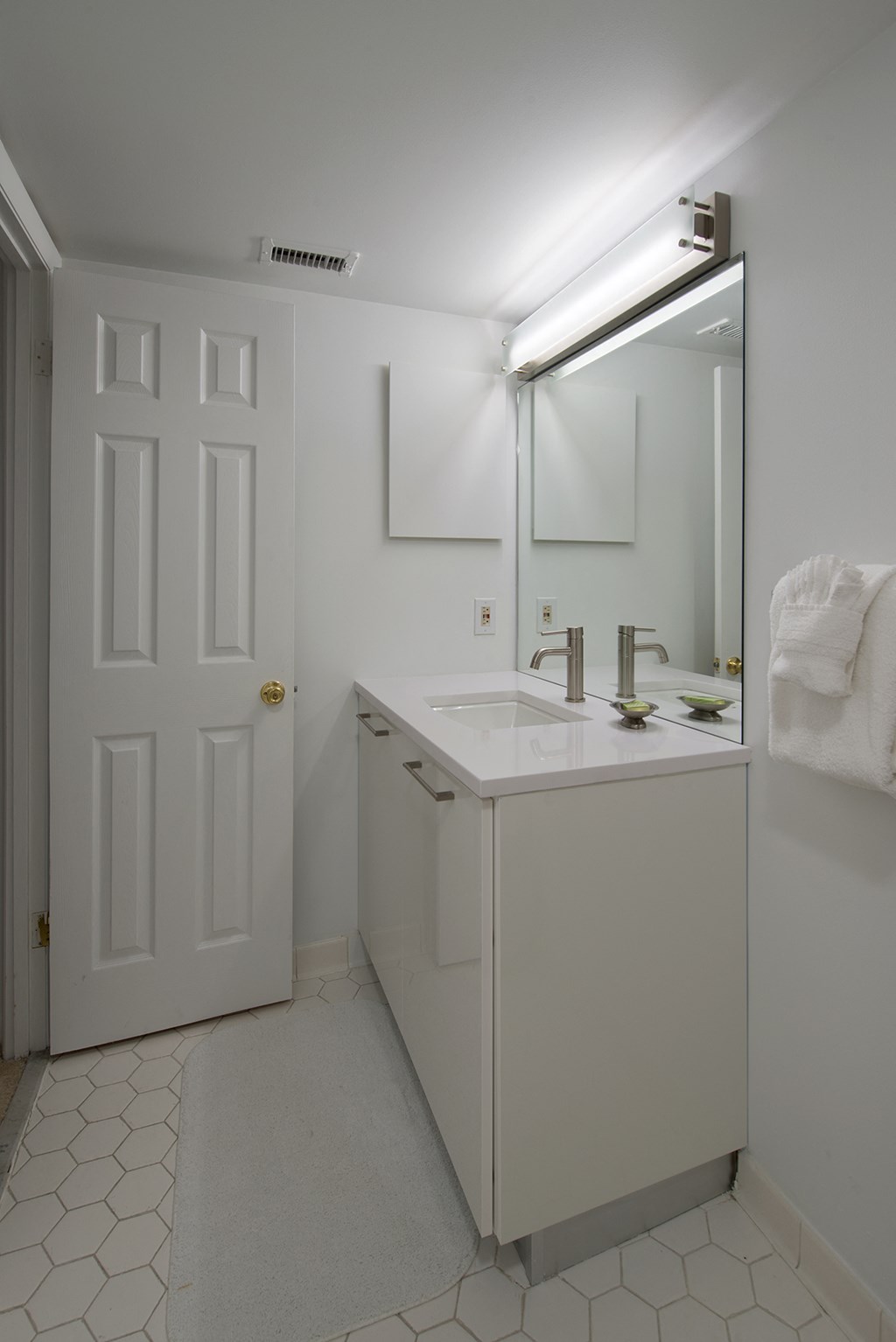a white bathroom with a sink and a mirror