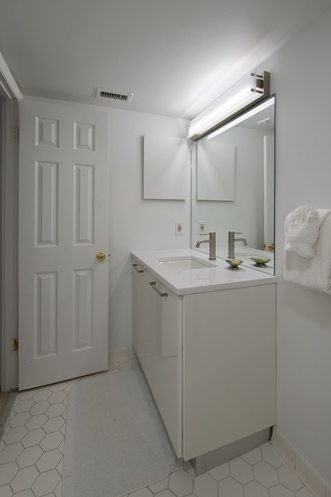 a white bathroom with a sink and a mirror